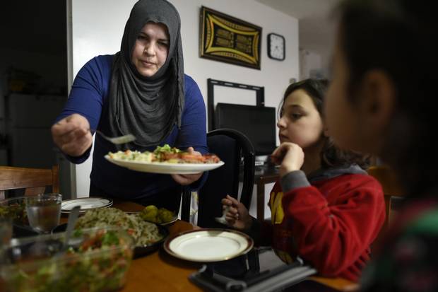 Abir Abdel Al Kader serves a late afternoon meal for her daughters Rama Al Dibel, 9, (C) and Rimas Al Dibel, 6.