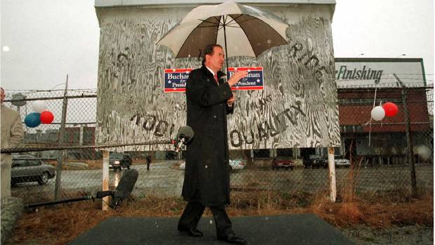 Republican U.S. presidential candidate Pat Buchanan stands alone in the rain on a small stage as he addresses a crowd at a campaign rally at the Clearwater Finishing Plant in Clearwater, South Carolina in Feb. 1996 ahead of the South Carolina primary.