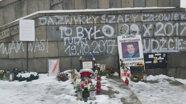 Outside Warsaw’s Palace of Culture, a makeshift memorial honours Piotr Szczesny, who lit himself on fire last October to protest against Poland's right-wing government.