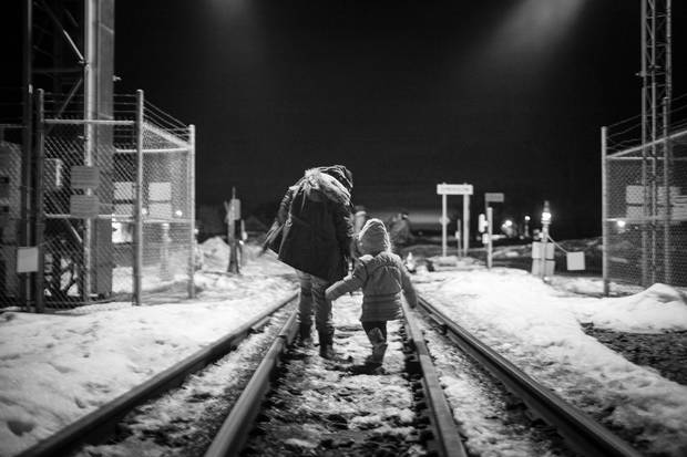 Two asylum seekers, a woman and young girl, cross the Canadian border, in Noyes, Minn.