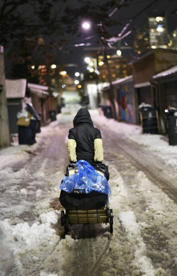 Wearing long sleeve protectors, a Chinese grandmother walks the streets of Toronto in search of wine and beer bottles with which to fill her buggy.