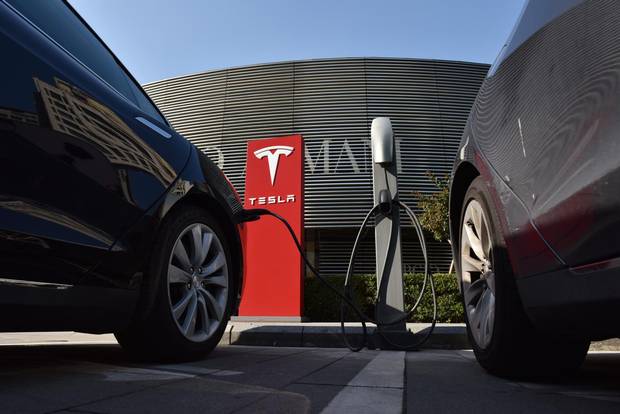 Tesla cars charge at a Tesla charging station outside a shopping mall in Beijing.