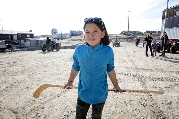A resident of Clyde River holds her ball hockey stick, a much-debated gift from the southerners on the Polar Prince. Michelle Valberg/Students on Ice Foundation.