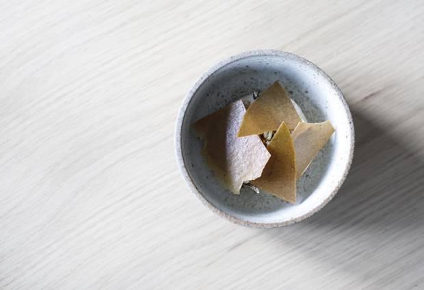 Caramelized sunchoke ice cream with crunchy, puffed wild rice and a sweet sunchoke tuile flecked on top.