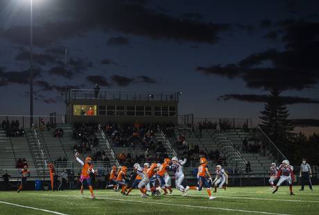 Ecole L’Odyssée Olympiens, in orange, and the Saint John Greyhounds compete on the field in Moncton on Friday.