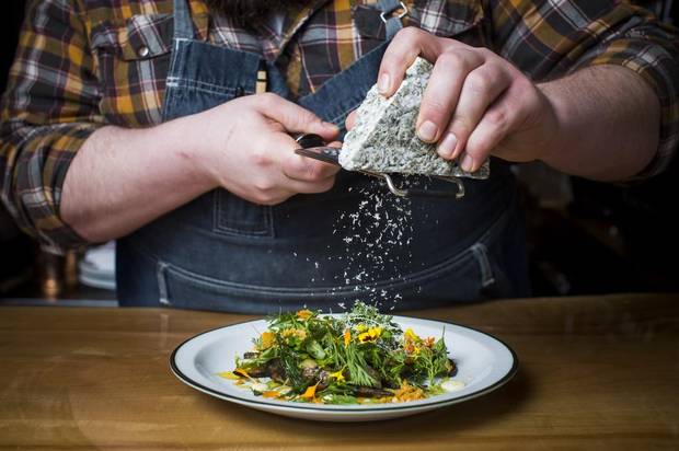 Chef Sean Reeve grates cheese over the Filled with Neglect dish.