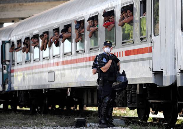 Croatian Police stand beside a train carrying migrants and refugees in a marshalling yard near Zagreb on September 18, 2015. A special train transporting some 1,500 people from Tovarnik, near the Serbian border, arrived in the Croatian capital where some Croats, recalling their own plight during the Balkan wars in the 1990s, offered aid.