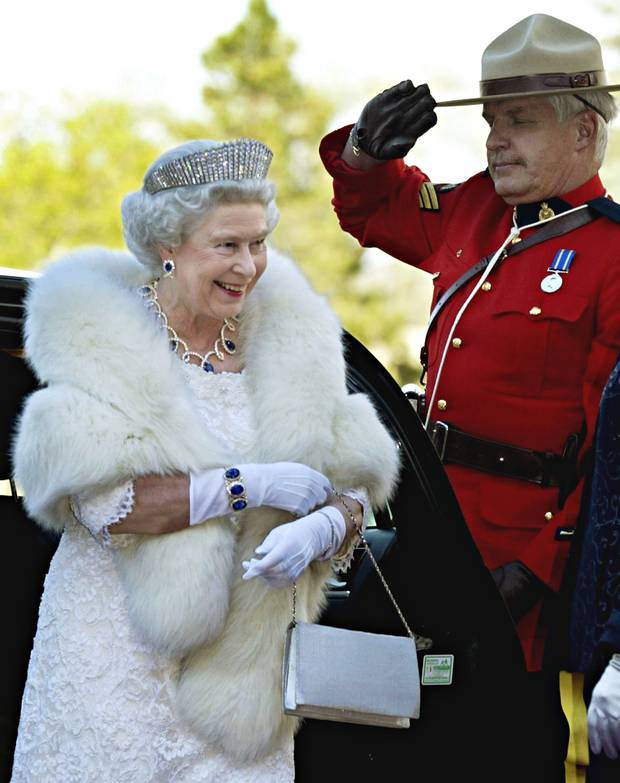 A Mountie salutes as the Queen arrives at an official dinner in Edmonton on May 24, 2005.