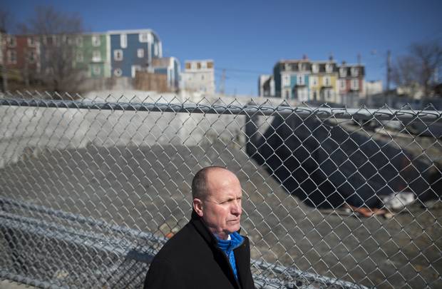 Realtor Larry Hann in front of an idle construction site in downtown St. John's where condos were set for development.