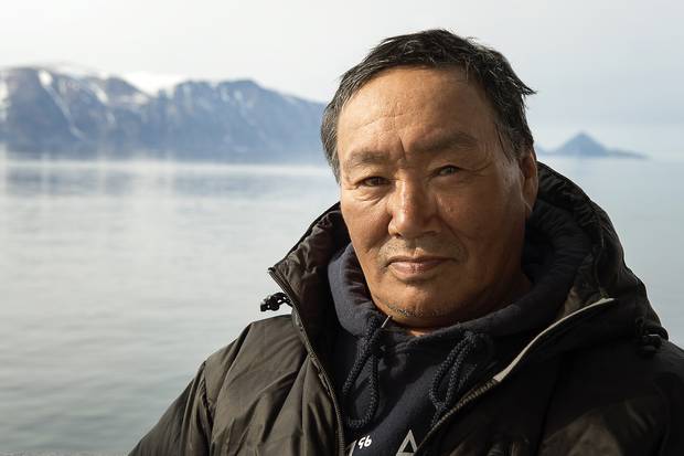 Sam Palituq, a longtime hunter from Clyde River, in Sam Ford Fjord. When he first camped in the fjord with his family forty years ago, the fjord’s glaciers reached the water. Today they hang halfway down the 2000 metre mountains. Michelle Valberg/Students on Ice Foundation.