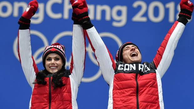 Canada's gold medallists Tessa Virtue (L) and Scott Moir celebrate on the podium during the medal ceremony for the figure skating ice dance during the Pyeongchang 2018 Winter Olympic Games in Pyeongchang on February 20, 2018.