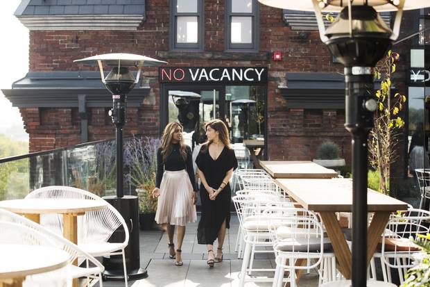 Natasha Deen, left, and Erika Hogerwaard walk on the rooftop patio of the Broadview Hotel in Toronto.