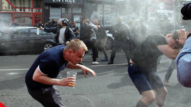 English fans run after getting sprayed with pepper spray by French police during scuffles in downtown Lille, northern France, June 15, 2016, one day ahead of the Euro 2016 Group B soccer match against Wales in nearby Lens.