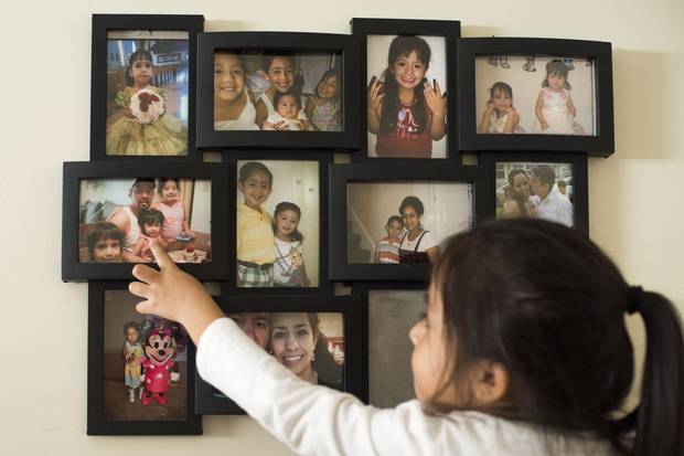 Mackaylah points to a wall of framed pictures of her siblings and parents.