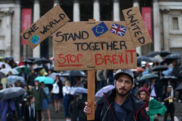 A demonstrator holds up a placard saying 