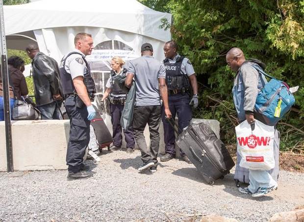 A group of asylum seekers cross the Canadian border at Champlain, N.Y., Friday, August 4, 2017.