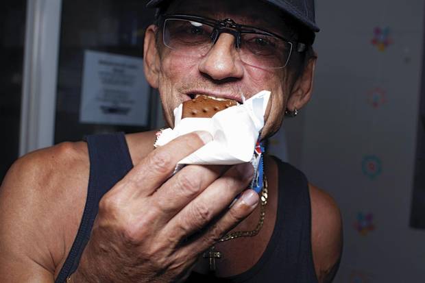 Richard Teague, a club facilitator, polishes off an ice cream sandwich.