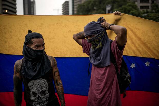 Two protesters get ready moments before clashing with Venezuelan security forces in Caracas.