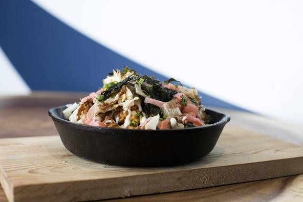 The Routine prepared with ramen, cheese curds, miso gravy, kewpie mayo, furikake, bonito and pickled ginger at The Rise Eatery.