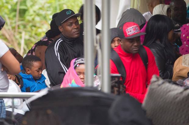 Asylum seekers wait to be processed by the Royal Canadian Mounted Police after crossing the Canada/US border near Hemmingford, Quebec.