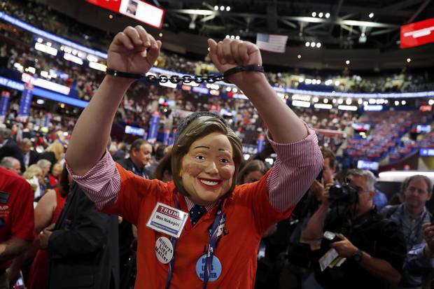 A delegate wearing a mask of Democratic presidential candidate Hillary Clinton, as well as handcuffs and a prison jumpsuit, appears on the convention floor.