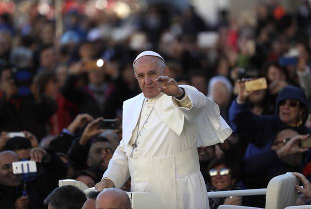 Pope Francis waves as he is driven across the crowd ahead of his weekly general audience in St. Peter’s Square at the Vatican on Nov. 9, 2016.
