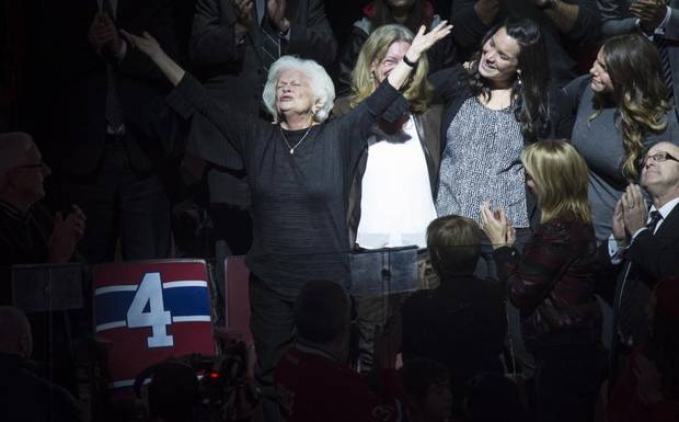 Elise Beliveau salutes the crowd as she stands next to her husband Montreal Canadiens legend Jean Beliveau's empty seat, during a ceremony prior to facing the Vancouver Canucks in NHL hockey action Tuesday.