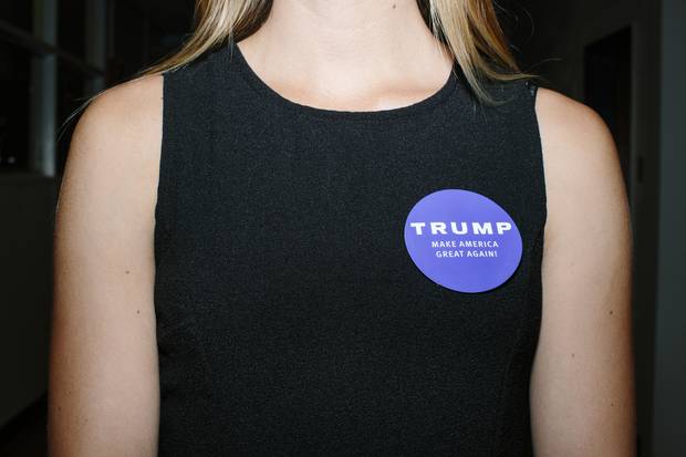 Campaign volunteer Andrea Nash, 21, of Hampton, N.H., wears a Trump campaign sticker while directing people to the overflow room before his speech at a rally at Winnacunnet High School.