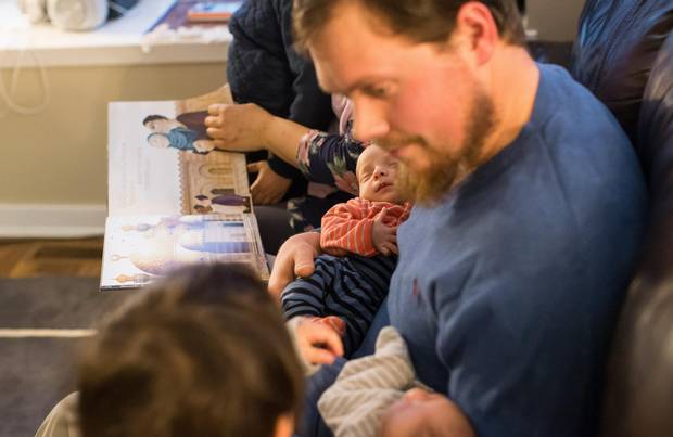 Parents Kelly and David Bathurst read to their children Yahya, 4, Nura, 2, and twins Ibrahim and Musa are their home in Burnaby.