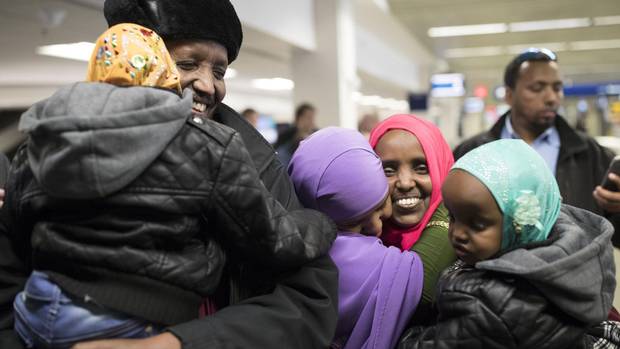 Mohamed Iye holds his 4-year-old daughter, Nimo, after being reunited with his wife, Saido Ahmed Abdille, centre right, and their other daughter Nafiso, 2, at Minneapolis’ Saint Paul International Airport near Bloomington, Minn., after arriving from Amsterdam on Sunday.