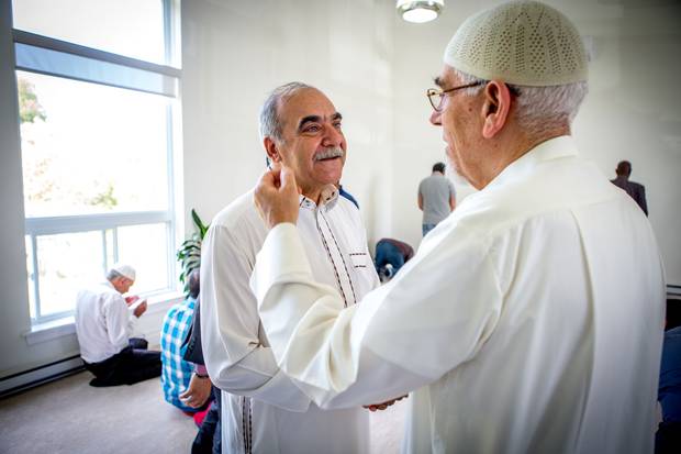 Mr. Sharbaji speaks with the mosque’s imam after prayers.