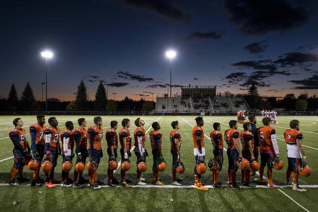 Members of Ecole L’Odyssée Olympiens stand for the national anthem before a game against the Saint John Greyhounds in Moncton on Friday.