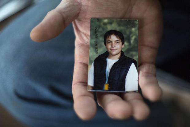 Mike Wells holds the childhood photo of his daughter Alloura who was born male and became as a trans woman later in life, at her memorial in Toronto on Tuesday.