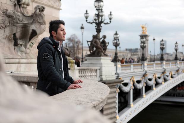 Mikahil looks out onto the Seine River from a bridge in Paris.