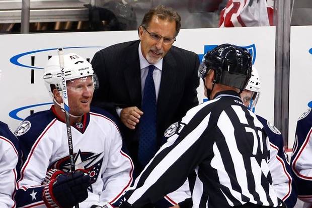 FILE - In this Oct. 8, 2016, file photo, Columbus Blue Jackets head coach John Tortorella, center, talks with linesman Brad Kovachik (71), with Scott Hartnell, left, listening during the first period of a preseason NHL hockey game against the Pittsburgh Penguins in Pittsburgh. Tortorella has returned to Ohio because of a family emergency, keeping him out of both Thursday night's game with Nashville and the NHL All-Star Game this weekend. (AP Photo/Gene J. Puskar, File)