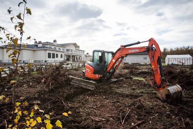 Construction equipment sits surrounded by dug-up blueberry bushes next to Mr. Fisher’s property. Mr. Fisher says the builders took out 1.5 acres from the 9.9-acre original farm to accommodate the building.