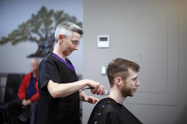 Lazio Barbershop owner Heather Oliver cuts Raphael Lapointe's hair near Canadian Forces Base Comox.