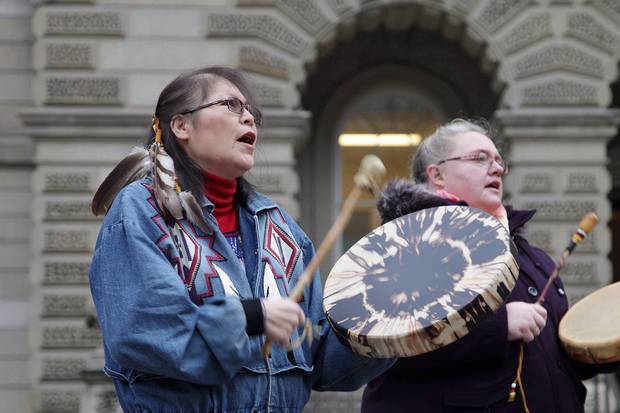 Marcia Brown Martel, left, drums outside court in Toronto on Dec. 1, 2016.