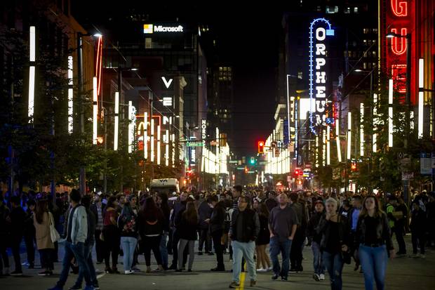 People fill Granville Street in Vancouver.