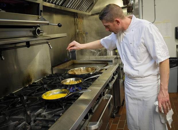 Chef J.P. Charpentier prepares a dish in the kitchen at the Royale Brasserie.