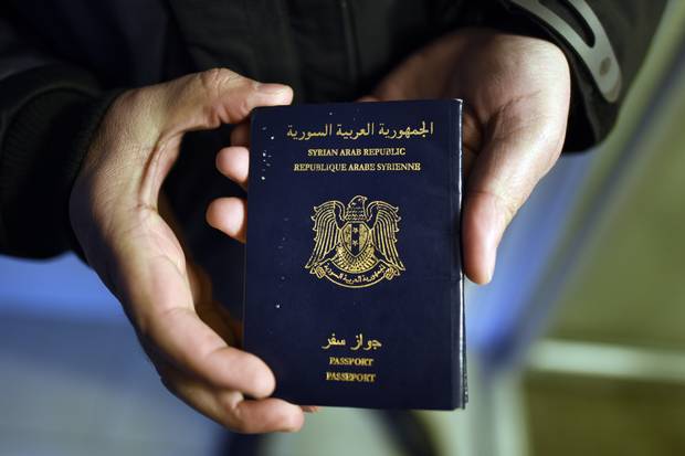 Narsis Bardakjian holds his Syrian passport while waiting to move into his new home in Canada on Dec. 23, 2015.