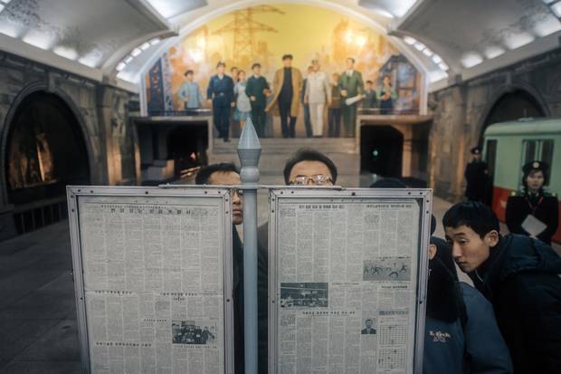 Commuters angle for a view of the day’s state newspaper while they wait for their subway train in Puhung Station. Though smartphones with access to North Korea’s self-contained intranet do exist, their cost puts them out of reach to all but a privileged few, and newspapers are the most common way of staying connected.