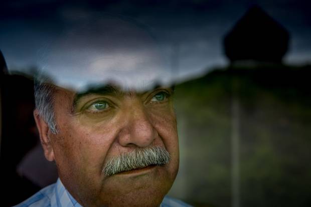 Mr. Sharbaji looks out the window of his apartment. He says he is constantly thinking about Syria and his family.