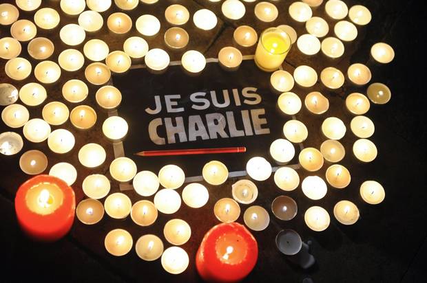 Candles are placed next to a sign reading ‘Je suis Charlie’ (I am Charlie) and a pen in La Rochelle, France, on Jan. 7, 2015, after the attack by armed gunmen on the offices of French satirical newspaper Charlie Hebdo in Paris.