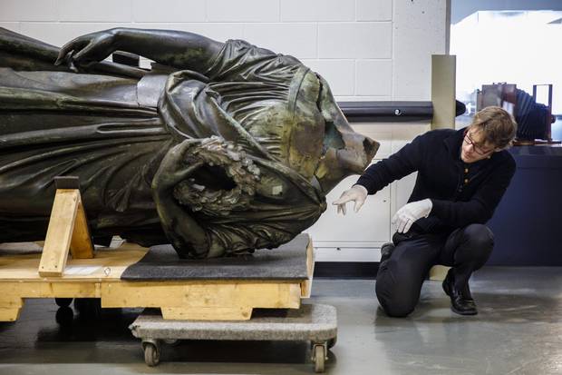 Art historian and museum curator Vincent Giguere examines the body of the Queen Victoria statue at the Musee de la Civilization archives in Quebec City on Monday, May 15, 2017. 