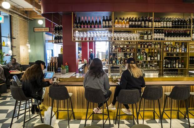People sit at the Bodega Bar at Campo.