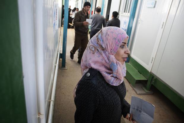Saja, a mother of three, holds her refugee application in her hand but is leaving the screening centre dejected. She received a 3 rating, meaning a decision has been deferred because her husband is not present in Jordan.