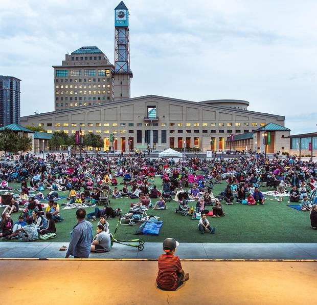 Families gather on a summer evening for an outdoor film screening in Mississauga's Celebration Square. The suburban belts outside of Toronto and Vancouver are historically where federal elections are won and lost.
