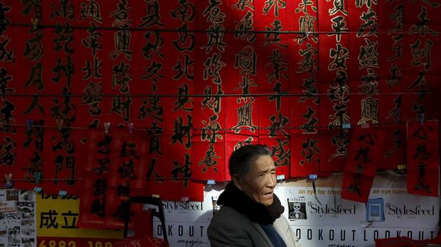 A man sells Chinese calligraphy with words of blessings on red papers for the upcoming Chinese New Year on a street in Hong Kong February 5, 2016.