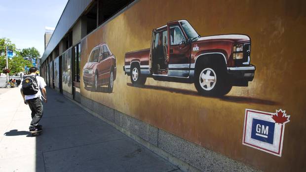 Pedestrians in downtown Oshawa, Ont. pass by murals painted on the walls of the bus station on July 20, 2013.